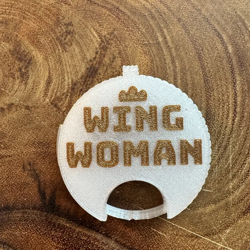 A clear Top Block with the line Wingwoman in gold